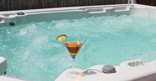 Multi-person hot tub with a drink in a martini glass sitting on the ledge